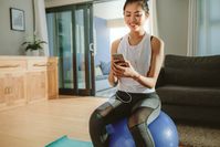 Imagen sobre el tema de la mujer con smartphone en fitness ball