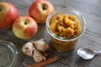 Imagen sobre el tema de la mermelada de jengibre en tarro sobre mesa de madera con manzanas