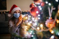 Imagen sobre el tema de la mujer con máscara decora el árbol de Navidad