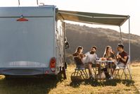 Imagen sobre el tema de un grupo frente a una autocaravana en unas vacaciones en camping